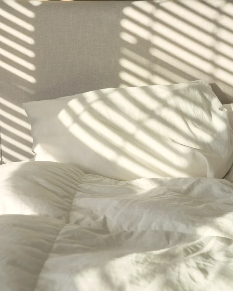 Lit fait, linge blanc, lumière du matin